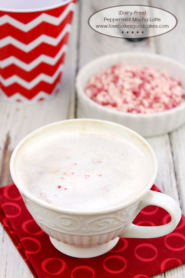 Dairy-Free Peppermint Mocha Latte in a cup with a bowl of peppermint flakes.