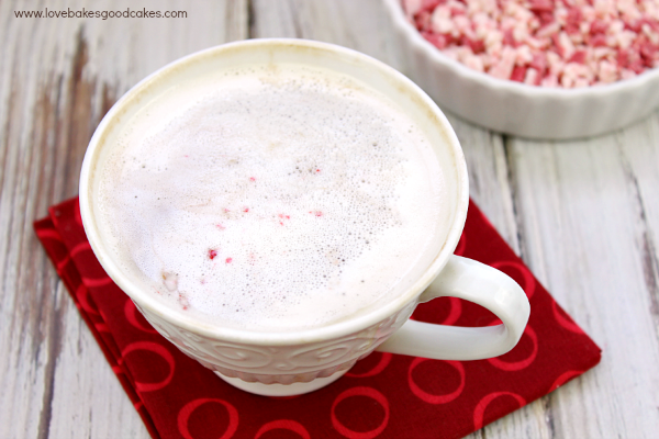 Dairy-Free Peppermint Mocha Latte in a cup with a bowl of peppermint pieces.