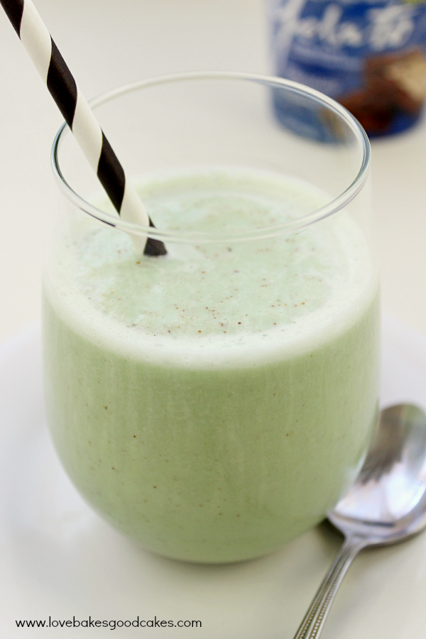 Dairy-Free Frozen Grasshopper in a clear glass with a straw and a spoon.