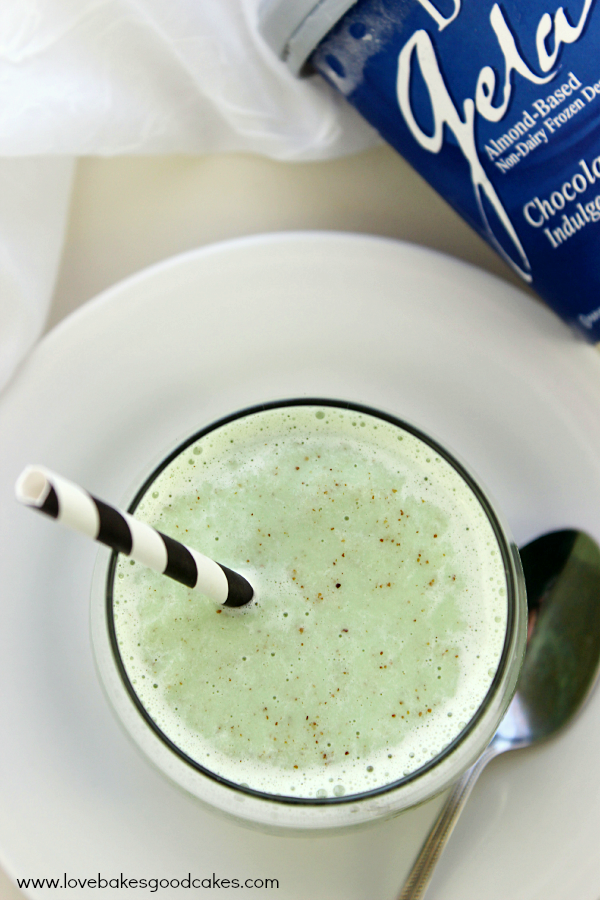 Dairy-Free Frozen Grasshopper in a glass with a straw and a spoon looking down into the glass.